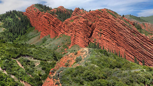 Jeti-Ögüz-rocks,-Kyrgyzstan man trekking near Jeti Ögüz rocks, Issyk Kul Region of Kyrgyzstan