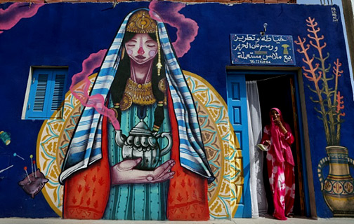 Spanish-artist-Malakkai-mural A-seamstress-stands-at-the-entrance-of-her-workshop-decorated-by-Spanish-artist-Malakkai