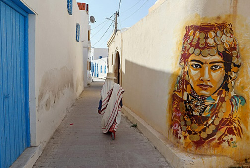 Spanish-artist-Btoy-wall-art A-Tunisian-woman-walks-past-a-mural-by-Spanish-artist-Btoy.-Photograph--Mohamed-Messara-EPA