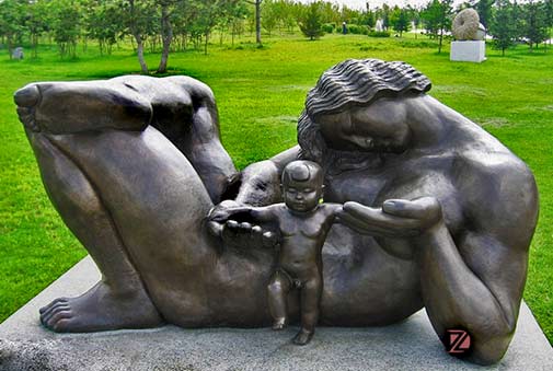 Bronze-mother-with-child-abstract-statues-DZ-sculptures reclining mother child sculpture - in green parklands