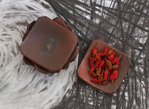 Catherine-White-ceramic-arts Catherine White---ceramic terracotta platters with red chillies on painted paper