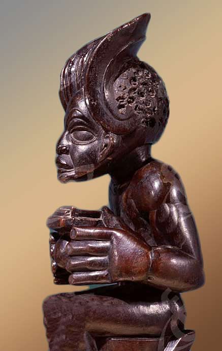 Sculpture-of-african-chief Chief-holding-a-sanza,-a-musical-instrument-of-the-ideophone-family,-with-metal-keys-and-gourd-resonator