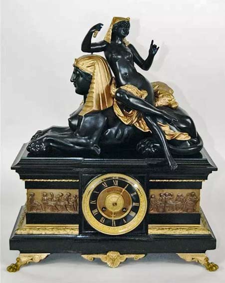 Egyptian-Revival-black-marble-mantle-clock Egyptian-Revival-black-marble-and-bronze-case-clock-with-surrounding-Roman-relief-on-animal-paw-feet,-Egyptian-figure-of-nude-woman-leaning-on-Sphinx