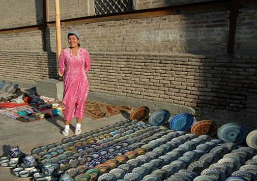 female-street-vendor-in-Bukhara Female street vendor in Bukhara with ceramic wares