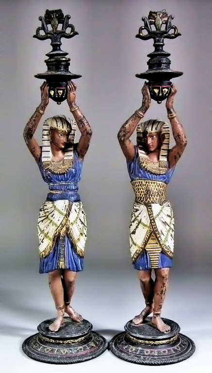 egyptian-revival-candlestick-pair Pair-of-early-20th-Century-painted-spelter-candlesticks,-Egyptian-revival,-male-and-female-figures-holding-candle-sconce
