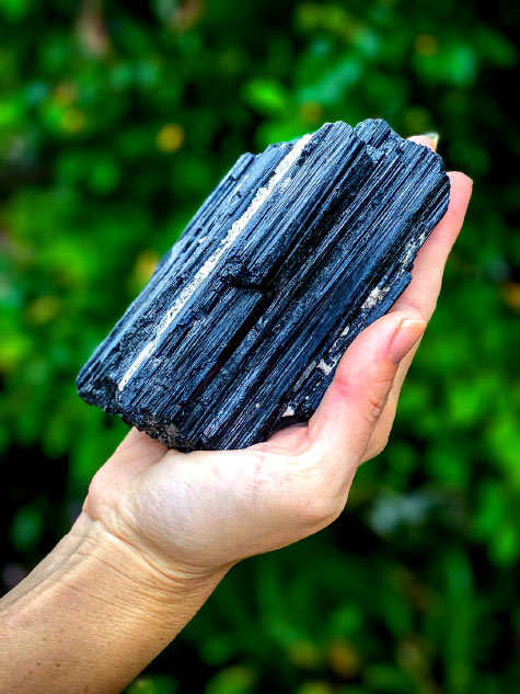 Purifying-black-Tourmaline- holding a black Tourmaline crystal
