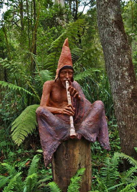 Forest-minstrel-sculpture-by-Bruno-Torfs Sculpture-Garden-Bruno-Torfs - Bush forest minstrel sitting on a tree stump