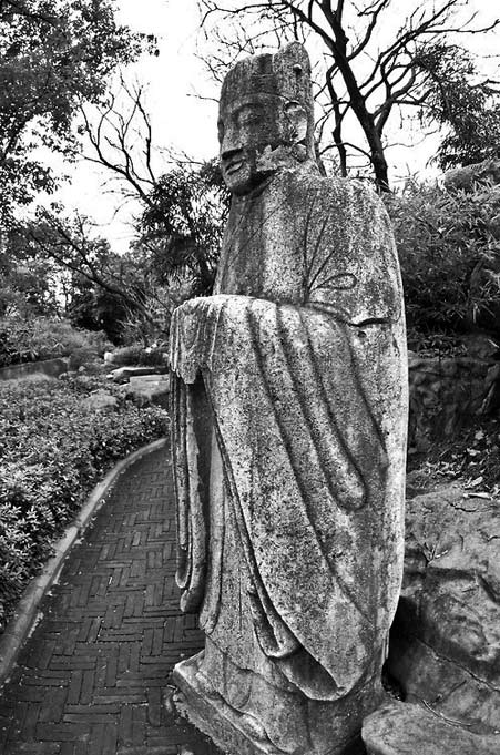 Statue-of-a-Buddhist-monk-China Statue-of-a-Standing Buddhist-monk,-located-in-a-garden-within-Seven-Star-Park,-Guilin,-China