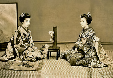 two-Maiko-with-a-Chrysanthemum-Ikebana two-Maiko-(Apprentice-Geisha)-seated-next-to-a-bamboo-vase-with-a-Chrysanthemum-Ikebana-arrangement-nordic-lotus